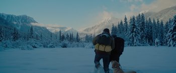 Movie still from “The Mountain Between Us” (2017), directed by Hany Abu-Assad – Two people are walking in the snow with a dog; Extreme Wide shot, Over the shoulder angle