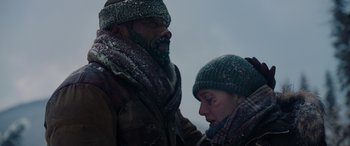 Movie still from “The Mountain Between Us” (2017), directed by Hany Abu-Assad – A man and a woman standing next to each other in the snow; Close Up shot, Low angle