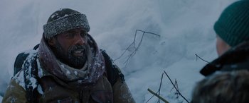 Movie still from “The Mountain Between Us” (2017), directed by Hany Abu-Assad – A man with a beard is talking on a cell phone in the snow; Close Up shot, Low angle