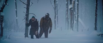 Movie still from “The Mountain Between Us” (2017), directed by Hany Abu-Assad – A man and a woman walking through the snow; Wide shot, Low angle