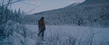 Movie still from “The Mountain Between Us” (2017), directed by Hany Abu-Assad – A man standing in the middle of a snow covered field; Extreme Wide shot, Low angle