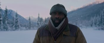 Movie still from “The Mountain Between Us” (2017), directed by Hany Abu-Assad – A man wearing a coat and a hat in the snow; Medium shot, Low angle