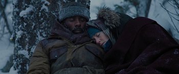 Movie still from “The Mountain Between Us” (2017), directed by Hany Abu-Assad – A man and a woman snuggling on top of a tree; Close Up shot, Low angle