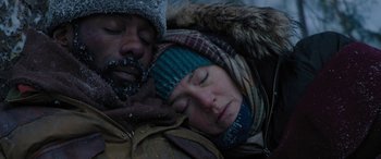 Movie still from “The Mountain Between Us” (2017), directed by Hany Abu-Assad – A man and a woman snuggled up in the snow; Close Up shot, Overhead angle