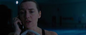 Movie still from “The Mountain Between Us” (2017), directed by Hany Abu-Assad – A person holding a towel near a swimming pool; Close Up shot, Over the shoulder angle