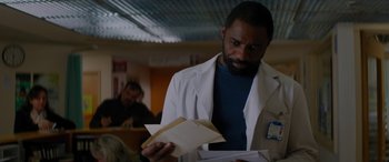 Movie still from “The Mountain Between Us” (2017), directed by Hany Abu-Assad – A man wearing a lab coat holding papers in his hands; Close Up shot, Over the shoulder angle