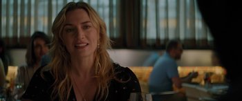 Movie still from “The Mountain Between Us” (2017), directed by Hany Abu-Assad – A woman sitting at a table holding a wine glass; Close Up shot, Over the shoulder angle