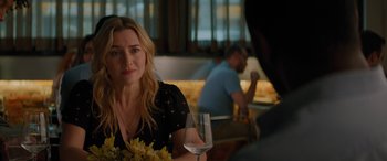 Movie still from “The Mountain Between Us” (2017), directed by Hany Abu-Assad – A woman sitting at a table holding a glass of wine; Close Up shot, Over the shoulder angle