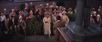 Movie still from “The Music Man” (1962), directed by Morton DaCosta – A group of people wearing hats standing next to each other; Wide shot, High angle
