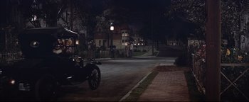 Movie still from “The Music Man” (1962), directed by Morton DaCosta – A motorcycle parked on the side of the road at night; Extreme Wide shot, High angle