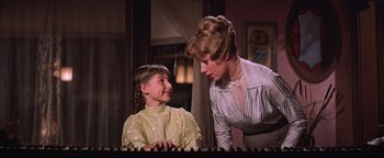 Movie still from “The Music Man” (1962), directed by Morton DaCosta – A woman standing next to a little girl; Medium shot, Low angle