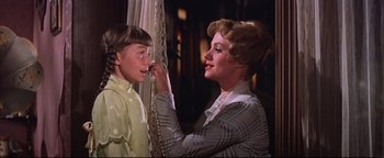 Movie still from “The Music Man” (1962), directed by Morton DaCosta – An older woman putting a chain around a young boy's face; Close Up shot, Low angle