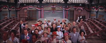 Movie still from “The Music Man” (1962), directed by Morton DaCosta – A large group of people wearing patriotic hats; Wide shot, High angle