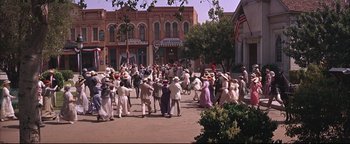 Movie still from “The Music Man” (1962), directed by Morton DaCosta – A crowd of people walking down a street; Extreme Wide shot, High angle