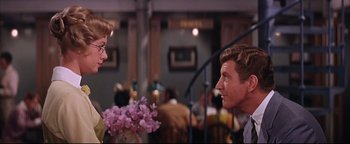 Movie still from “The Music Man” (1962), directed by Morton DaCosta – A man and a woman are talking in a restaurant; Medium shot, Over the shoulder angle