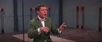 Movie still from “The Music Man” (1962), directed by Morton DaCosta – A man wearing a green jacket and a bow tie; Medium shot, Low angle