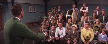 Movie still from “The Music Man” (1962), directed by Morton DaCosta – A group of young men sitting in front of each other holding musical instruments; Medium shot, High angle