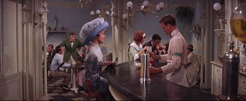Movie still from “The Music Man” (1962), directed by Morton DaCosta – A man and a woman sitting at a bar; Medium shot, Over the shoulder angle