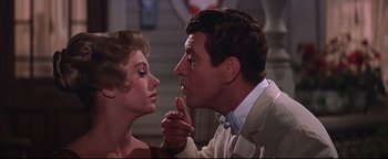 Movie still from “The Music Man” (1962), directed by Morton DaCosta – A man and a woman face to face in front of a staircase; Close Up shot, Low angle