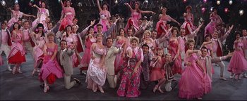 Movie still from “The Music Man” (1962), directed by Morton DaCosta – A large group of people in pink dresses; Wide shot, High angle
