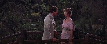 Movie still from “The Music Man” (1962), directed by Morton DaCosta – A man and a woman standing next to each other on a bridge; Medium shot, Over the shoulder angle