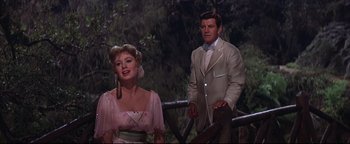 Movie still from “The Music Man” (1962), directed by Morton DaCosta – A man and a woman standing next to each other; Medium shot, Low angle