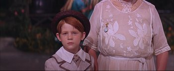 Movie still from “The Music Man” (1962), directed by Morton DaCosta – A young boy wearing a hat standing next to an older woman; Close Up shot, High angle