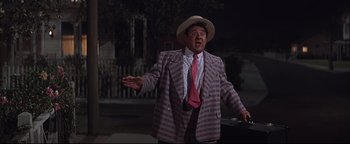 Movie still from “The Music Man” (1962), directed by Morton DaCosta – A man wearing a striped suit and a hat; Medium shot, Low angle