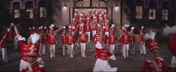 Movie still from “The Music Man” (1962), directed by Morton DaCosta – A group of men in red and white marching uniforms; Wide shot, Low angle