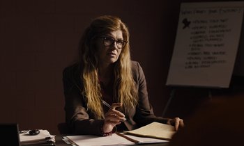 Movie still from “The Mustang” (2019), directed by Laure de Clermont-Tonnerre – A woman sitting at a table with a pen and paper; Medium shot, Over the shoulder angle