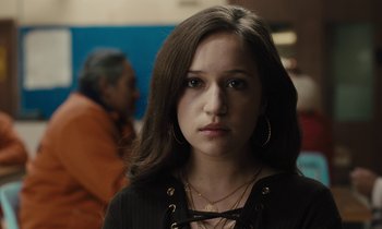 Movie still from “The Mustang” (2019), directed by Laure de Clermont-Tonnerre – A young woman with long brown hair wearing a black shirt; Close Up shot, Over the shoulder angle