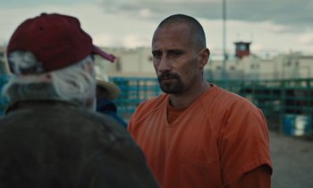Movie still from “The Mustang” (2019), directed by Laure de Clermont-Tonnerre – A man in an orange shirt is talking to a man in a red hat; Close Up shot, Over the shoulder angle