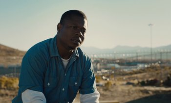 Movie still from “The Mustang” (2019), directed by Laure de Clermont-Tonnerre – A man in a blue shirt is sitting on a hill; Close Up shot, Low angle