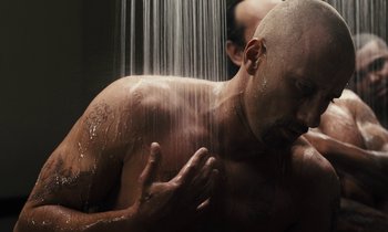 Movie still from “The Mustang” (2019), directed by Laure de Clermont-Tonnerre – A man is taking a shower in a bathroom; Close Up shot, Over the shoulder angle