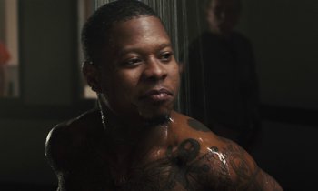 Movie still from “The Mustang” (2019), directed by Laure de Clermont-Tonnerre – A person with a tattoo in a shower; Close Up shot, Over the shoulder angle