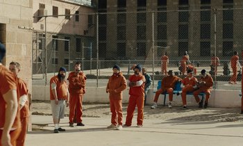 Movie still from “The Mustang” (2019), directed by Laure de Clermont-Tonnerre – A group of men in orange jumpsuits standing next to each other; Wide shot, High angle