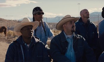 Movie still from “The Mustang” (2019), directed by Laure de Clermont-Tonnerre – A group of men wearing cowboy hats in a field; Medium shot, High angle