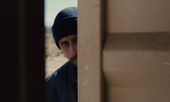 Movie still from “The Mustang” (2019), directed by Laure de Clermont-Tonnerre – A man wearing a hat looking out of a window; Close Up shot, Over the shoulder angle