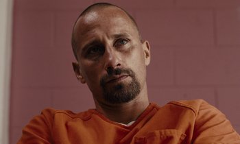 Movie still from “The Mustang” (2019), directed by Laure de Clermont-Tonnerre – A person wearing an orange shirt; Close Up shot, Low angle