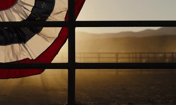 Movie still from “The Mustang” (2019), directed by Laure de Clermont-Tonnerre – A view through a window of a field with a fence; Wide shot, Low angle