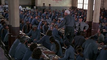 Movie still from “Naked Gun 33 1/3: The Final Insult” (1994), directed by Peter Segal – A group of people sitting around a table eating food; Wide shot, High angle