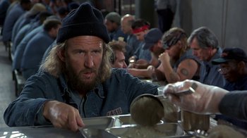 Movie still from “Naked Gun 33 1/3: The Final Insult” (1994), directed by Peter Segal – A group of people sitting around a table; Medium shot, High angle