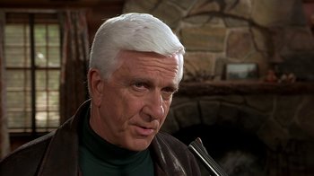 Movie still from “Naked Gun 33 1/3: The Final Insult” (1994), directed by Peter Segal – An older man with white hair looking at the camera; Close Up shot, Low angle
