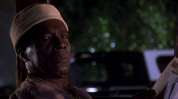 Movie still from “Naked Gun 33 1/3: The Final Insult” (1994), directed by Peter Segal – An older man wearing a white hat sitting in front of a tree; Close Up shot, Low angle