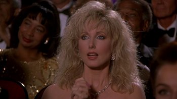 Movie still from “Naked Gun 33 1/3: The Final Insult” (1994), directed by Peter Segal – A person with long hair; Close Up shot, Over the shoulder angle