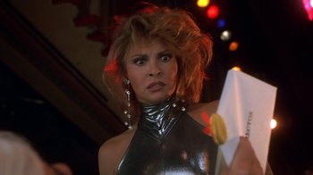 Movie still from “Naked Gun 33 1/3: The Final Insult” (1994), directed by Peter Segal – A person holding a hot dog in her hand; Close Up shot, Over the shoulder angle