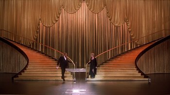 Movie still from “Naked Gun 33 1/3: The Final Insult” (1994), directed by Peter Segal – Two men in suits sitting at the top of a set of stairs; Extreme Wide shot, High angle