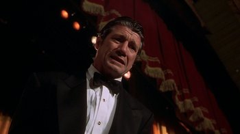 Movie still from “Naked Gun 33 1/3: The Final Insult” (1994), directed by Peter Segal – A man wearing a tuxedo and a bow tie; Close Up shot, Low angle