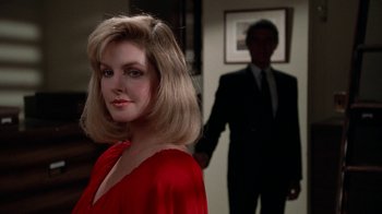 Movie still from “The Naked Gun: From the Files of Police Squad!” (1988), directed by David Zucker – A woman in a red dress standing in front of a man in a suit; Close Up shot, Over the shoulder angle