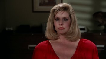 Movie still from “The Naked Gun: From the Files of Police Squad!” (1988), directed by David Zucker – A woman in a red dress is posing for a picture; Close Up shot, Over the shoulder angle